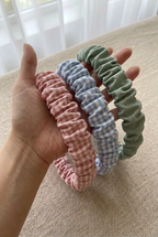 Bandas de vichy y verde salvia sostenidas por una mano femenina