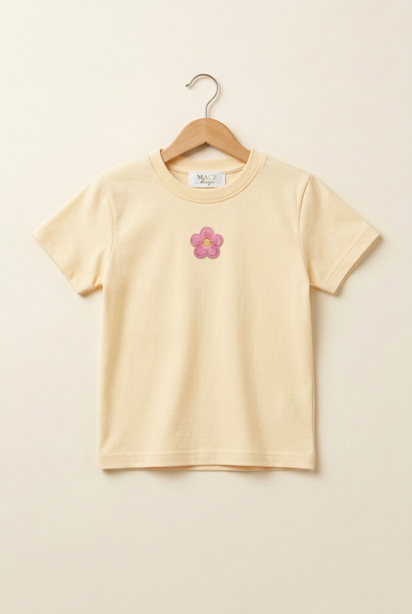 Camiseta infantil amarillo mantequilla pastel claro con flor rosa pequeña