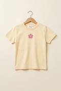Camiseta infantil amarillo mantequilla pastel claro con flor rosa pequeña