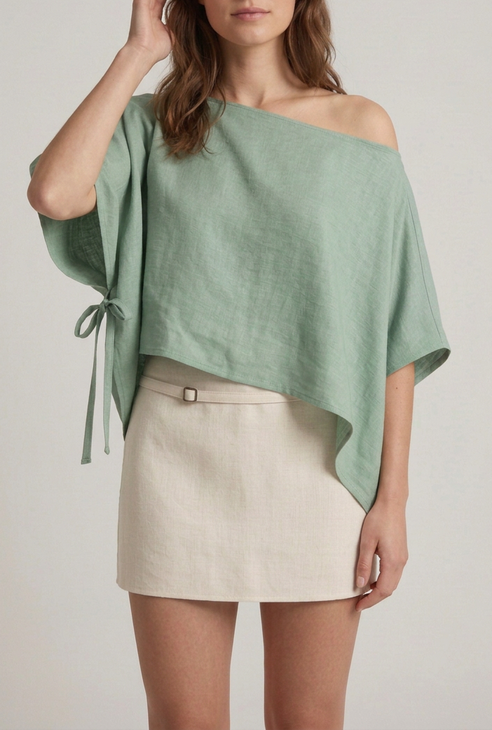Modelo con una mano junto al rostro y blusa verde por fuera
